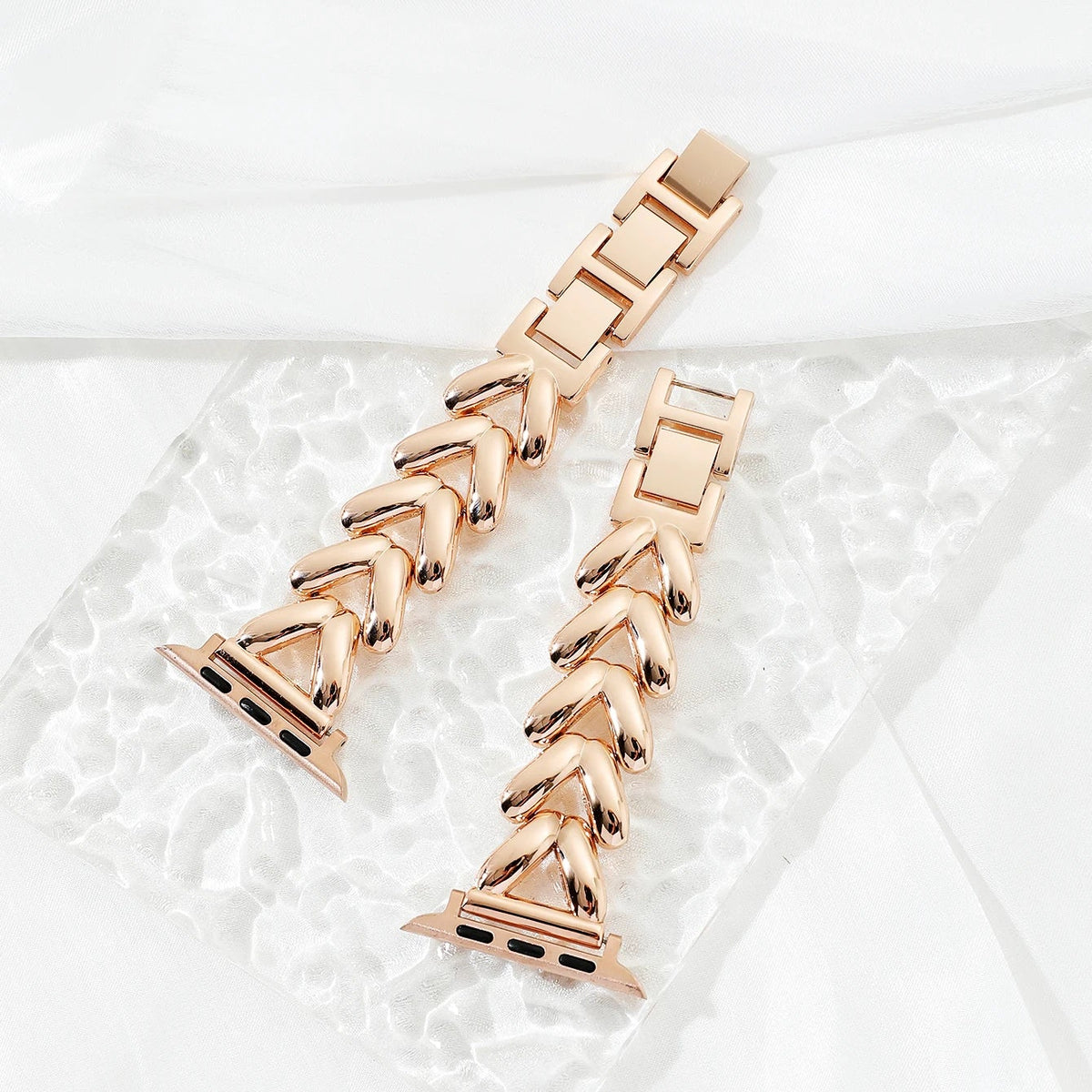 Two rose gold watch bands on a white background